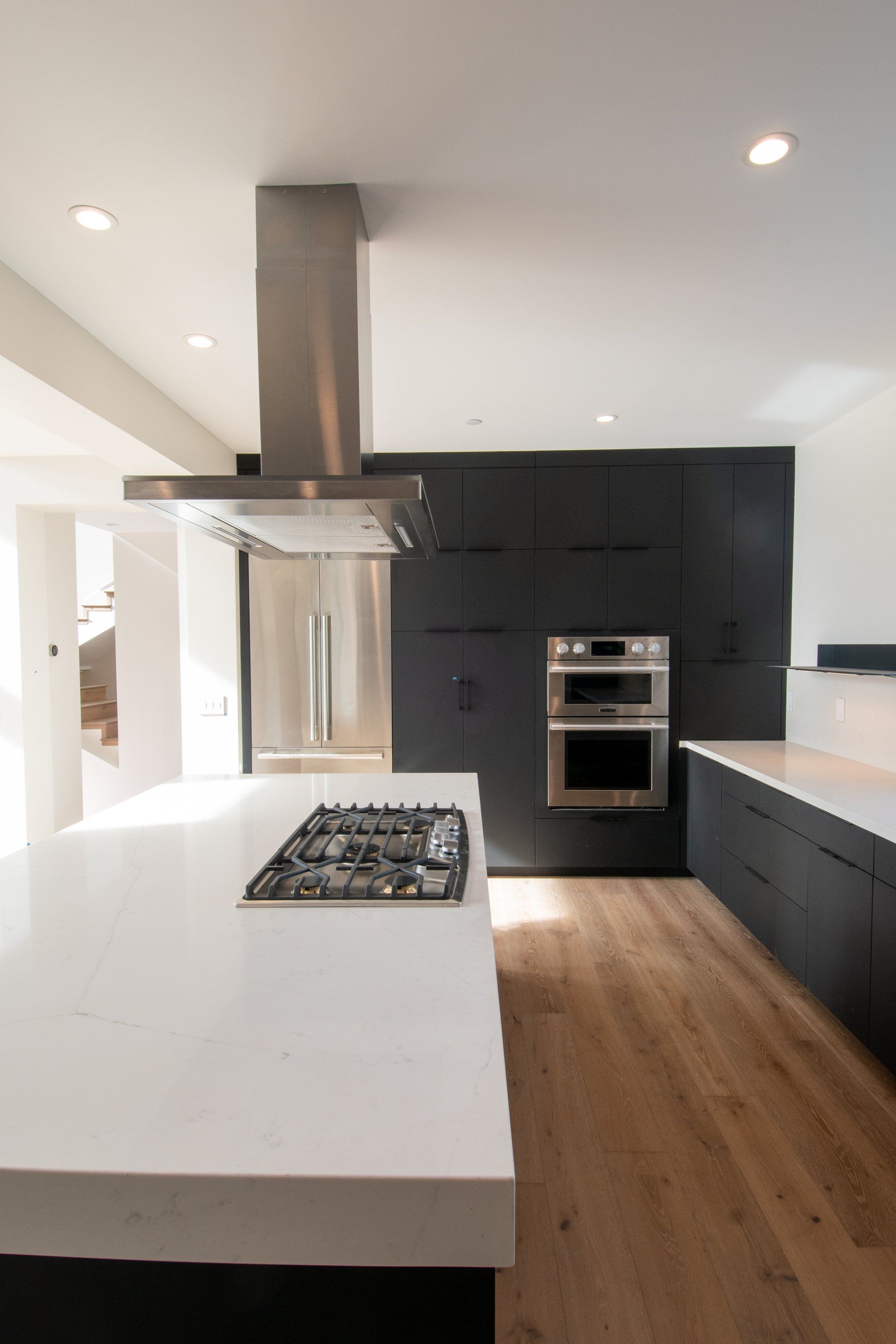 A kitchen with a stove top oven and a refrigerator