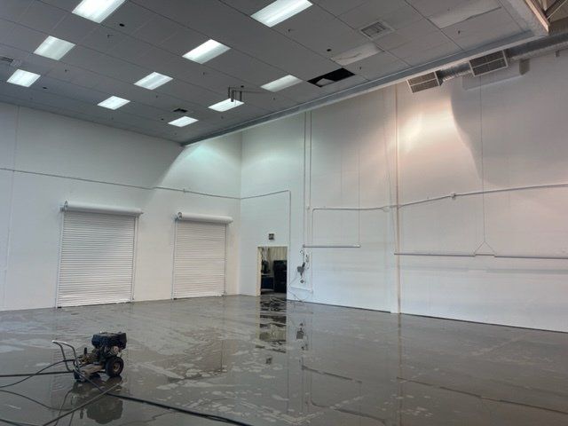 A large empty room with a reflection of a person in the floor