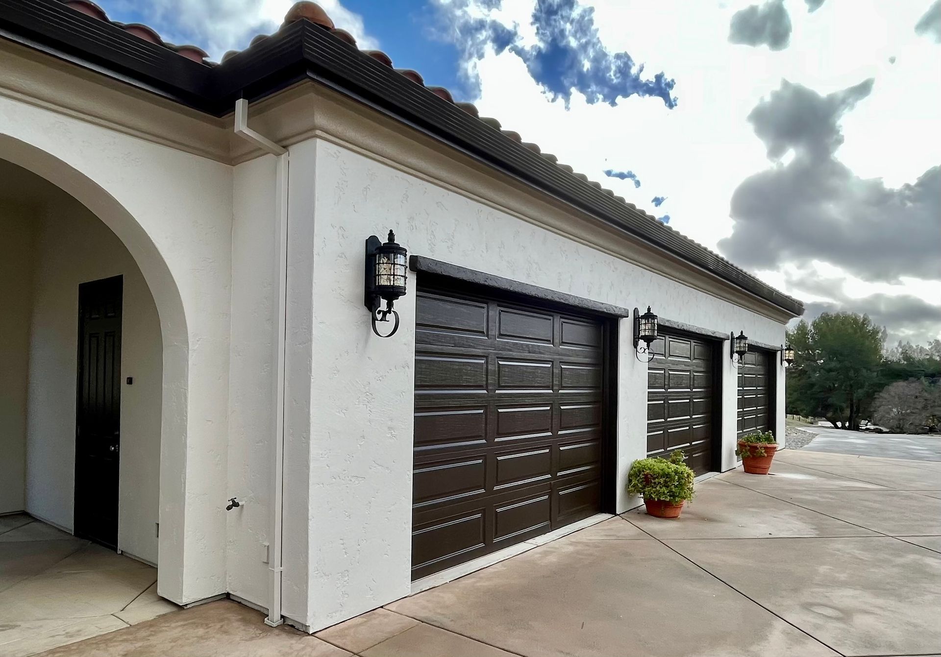 A white house with two brown garage doors