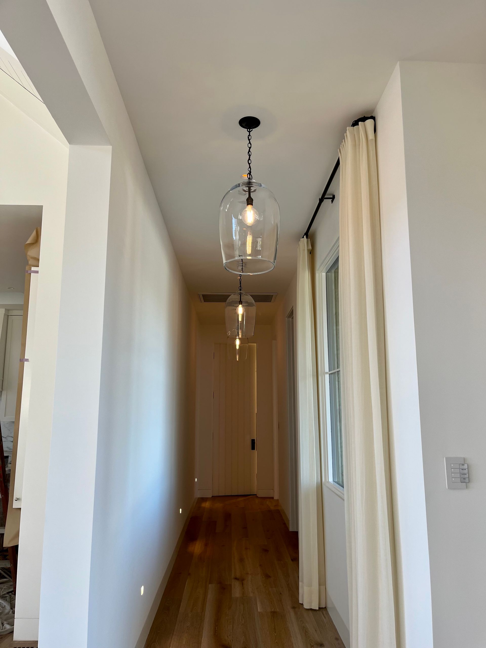 A long hallway with a light hanging from the ceiling