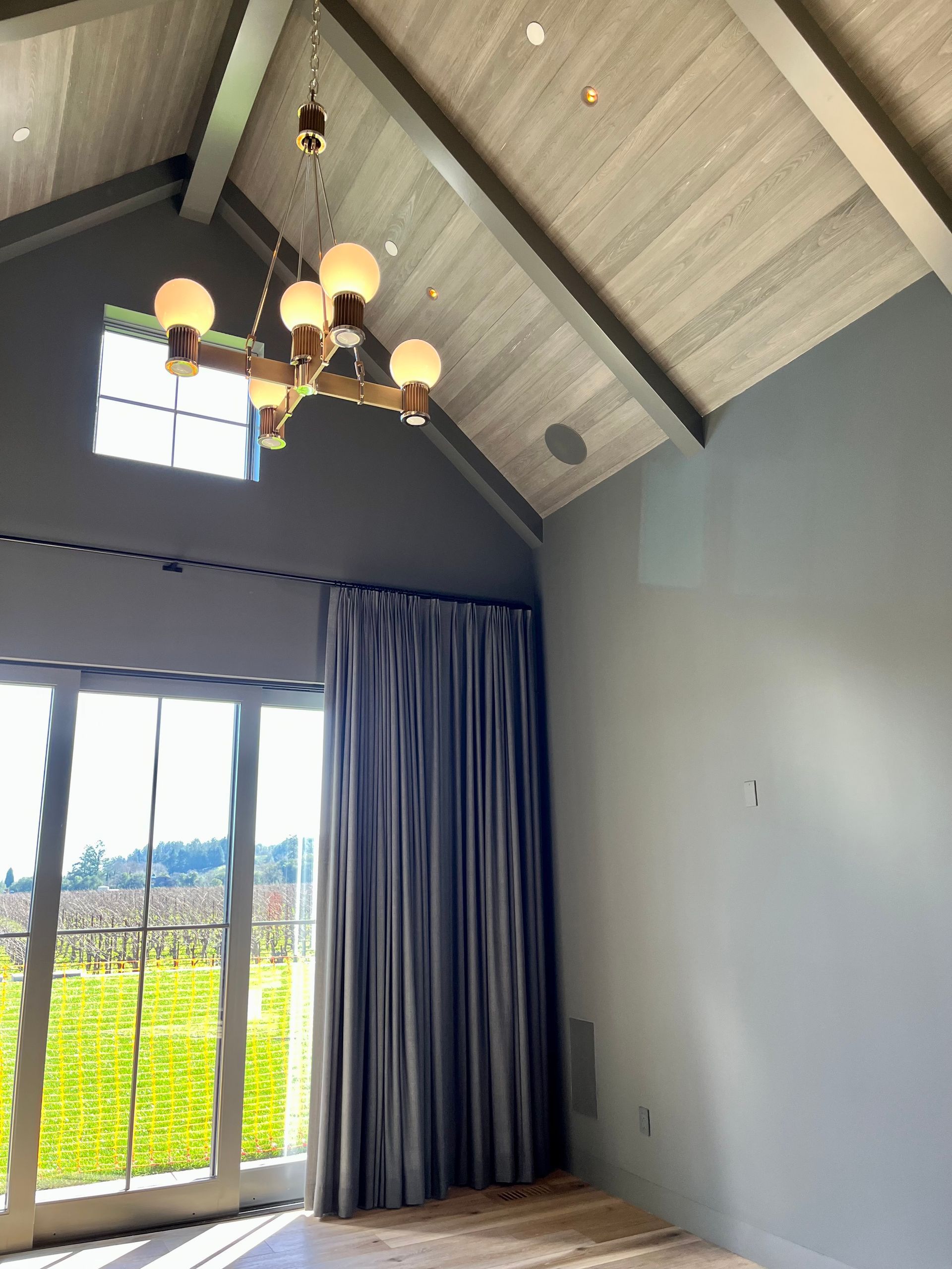 An empty room with a chandelier hanging from the ceiling