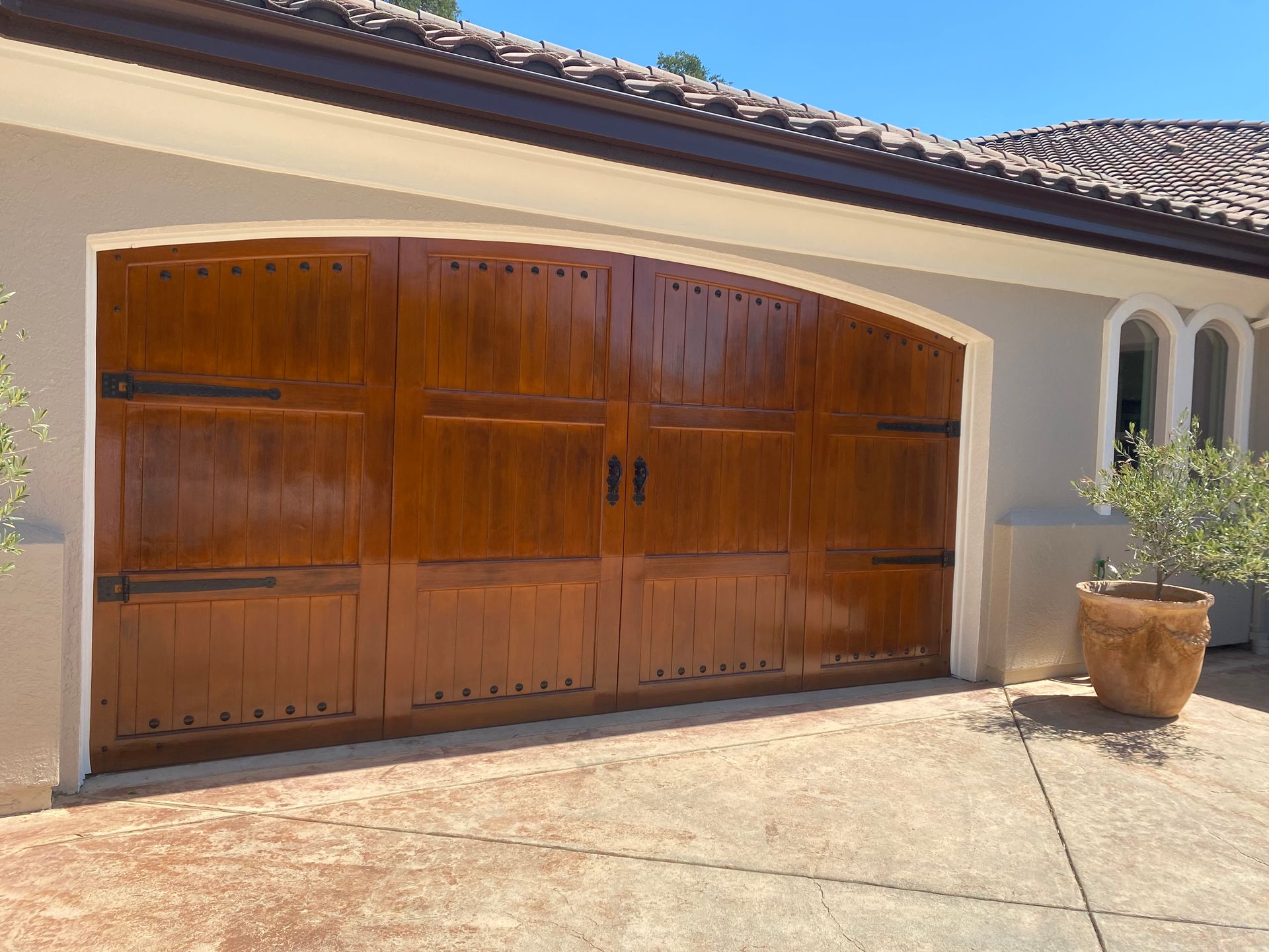 A large wooden garage door is sitting in front of a house.