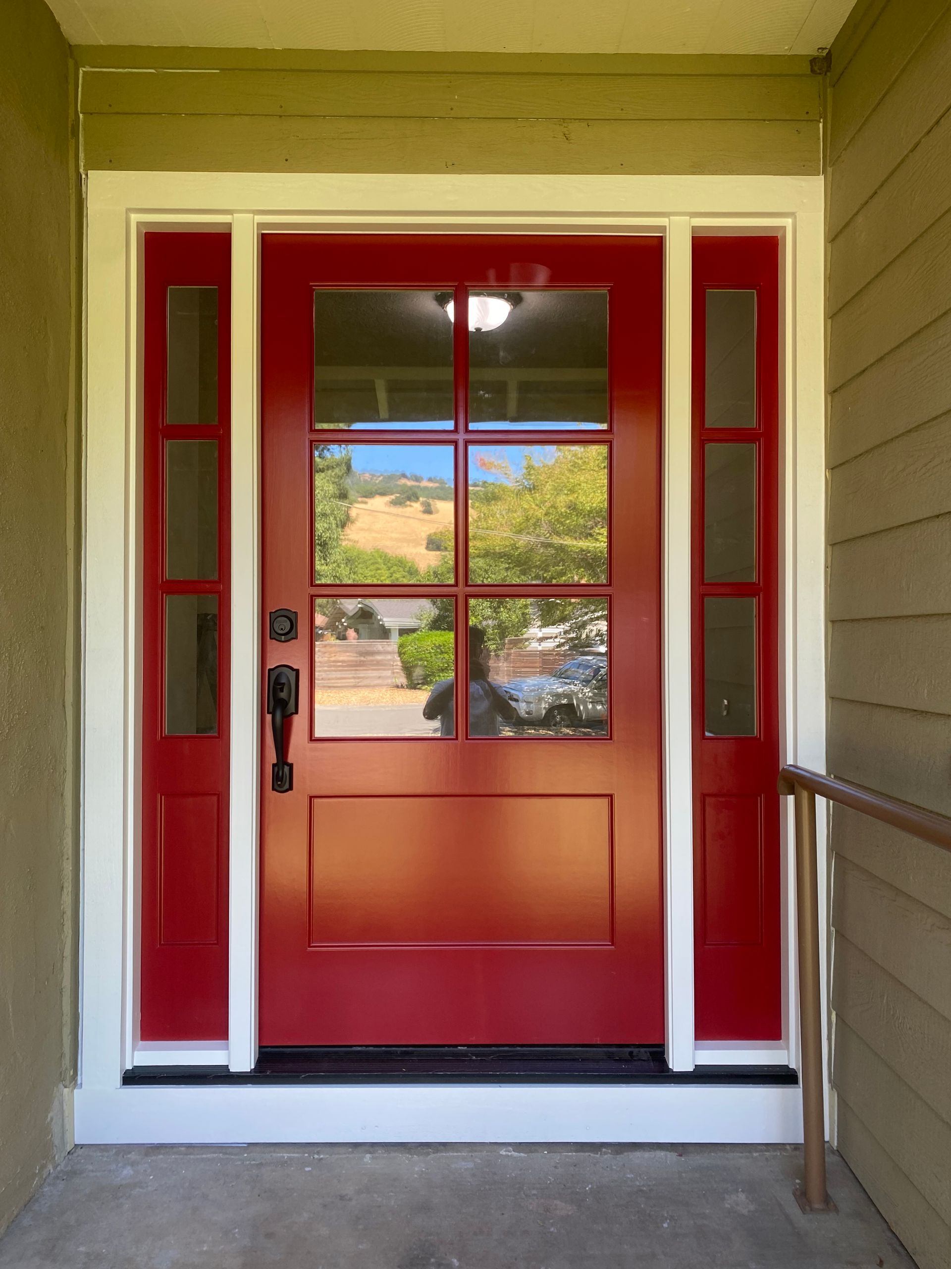 A red front door with a white trim and glass