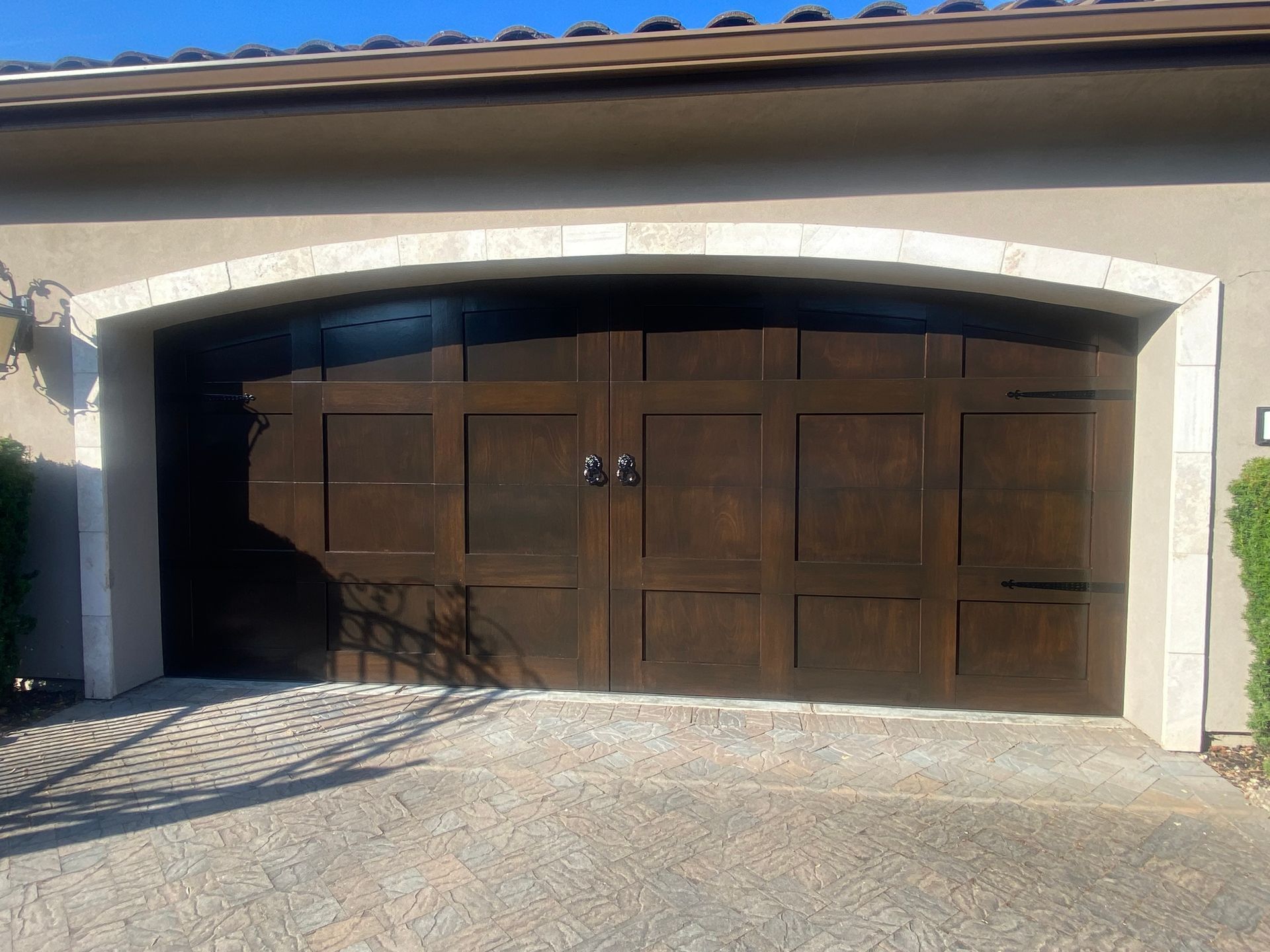 A large wooden garage door is sitting in front of a house