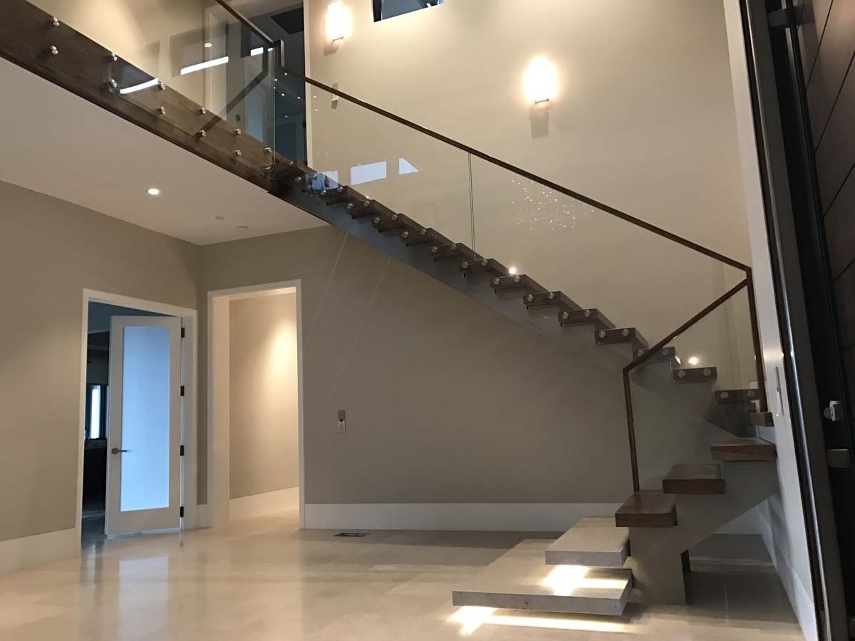 An empty room with a staircase and a glass railing