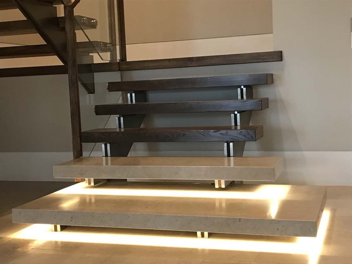 A staircase with a light on the bottom step