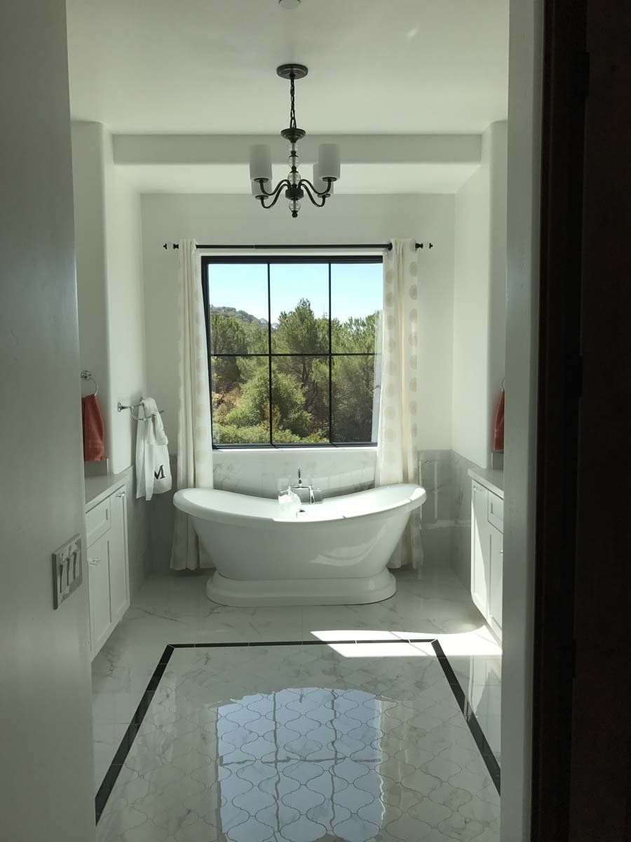 A bathroom with a tub and a window.