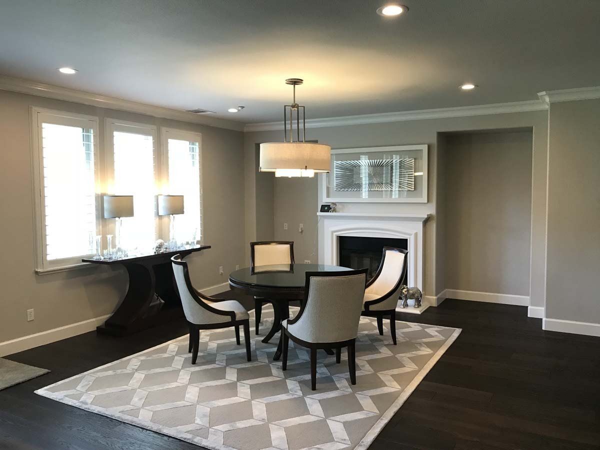A dining room with a table and chairs and a fireplace.