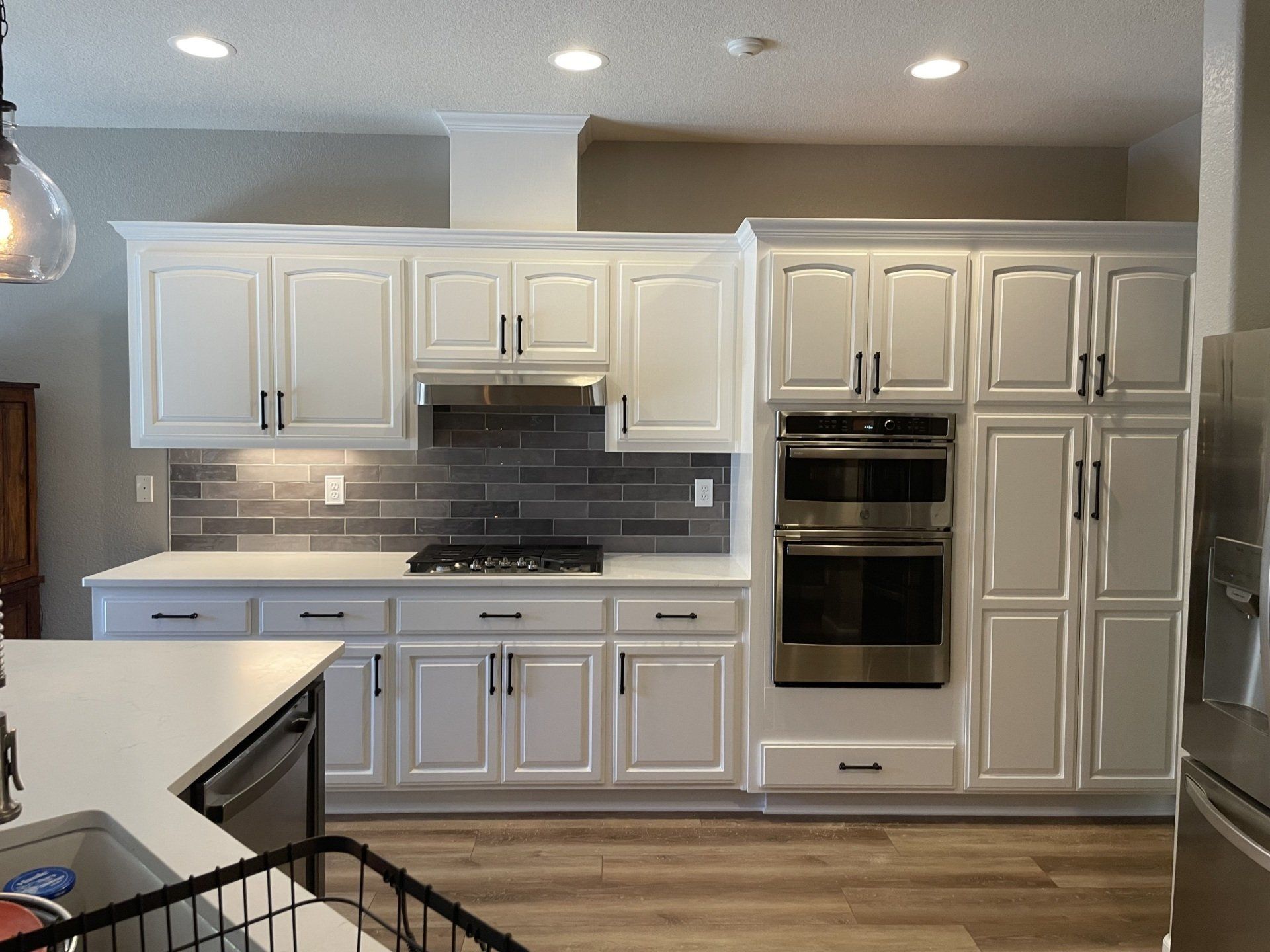 A kitchen with white cabinets and stainless steel appliances