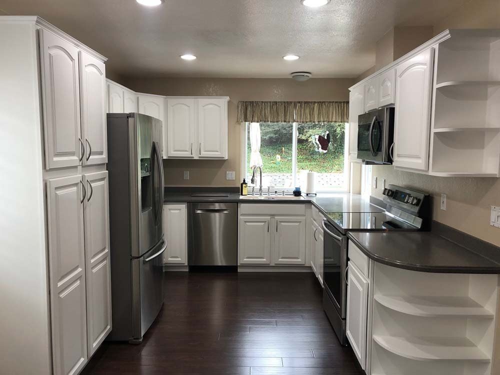 A kitchen with white cabinets and stainless steel appliances.