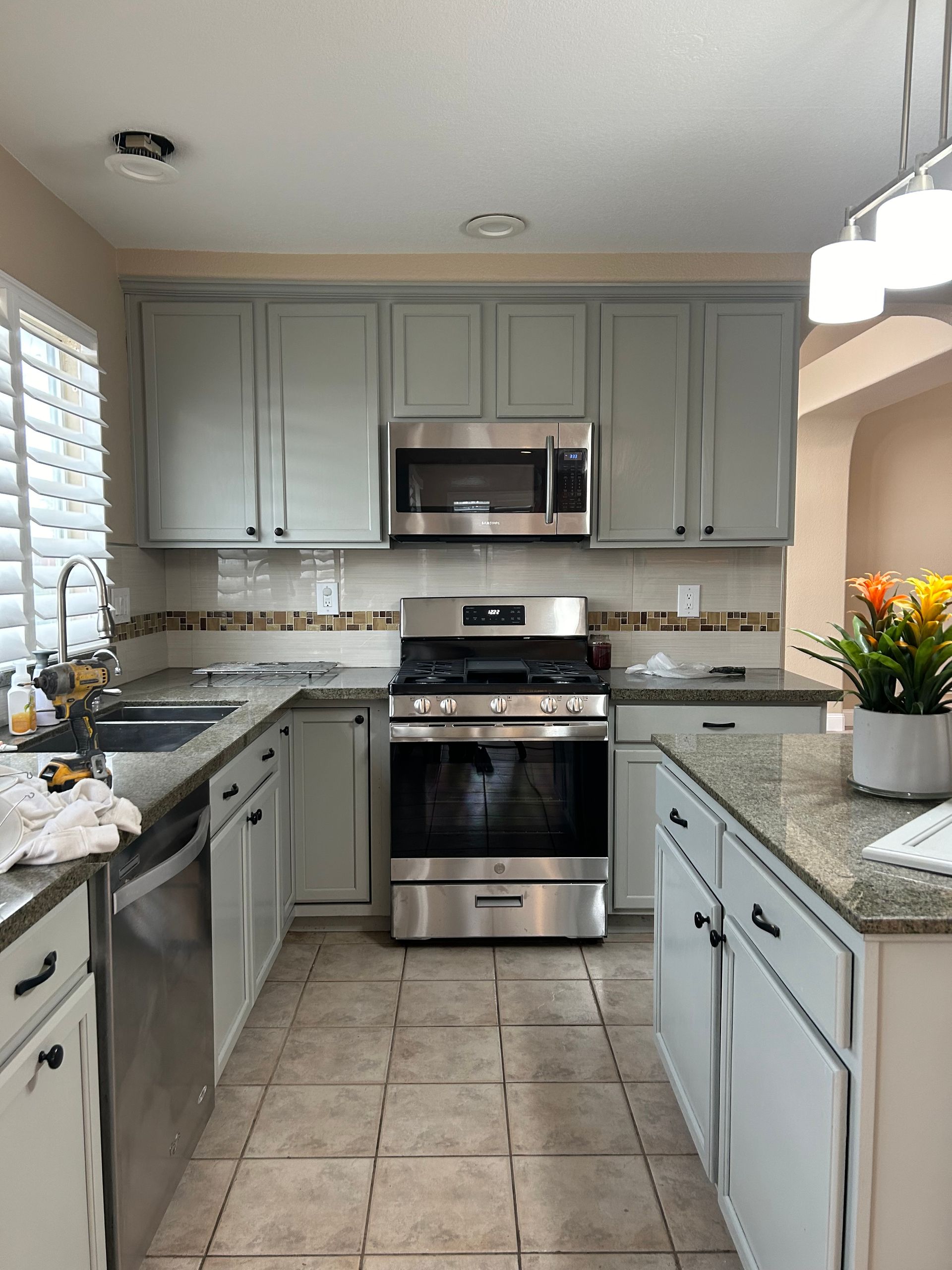 A kitchen with stainless steel appliances and white cabinets.