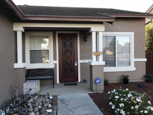 A small house with a brown door and white trim