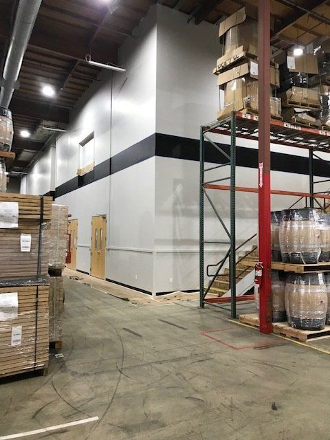 A large warehouse filled with lots of boxes and barrels