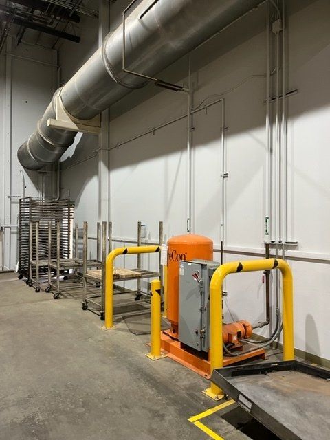 A warehouse with a lot of pipes and a machine that says icon on it