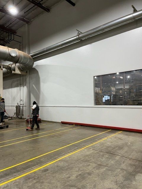 A man is pushing a pallet truck in a warehouse
