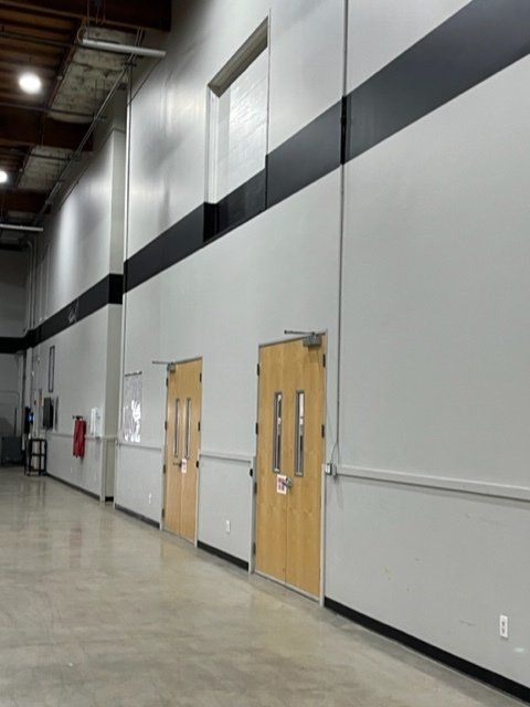 A long hallway with wooden doors and white walls
