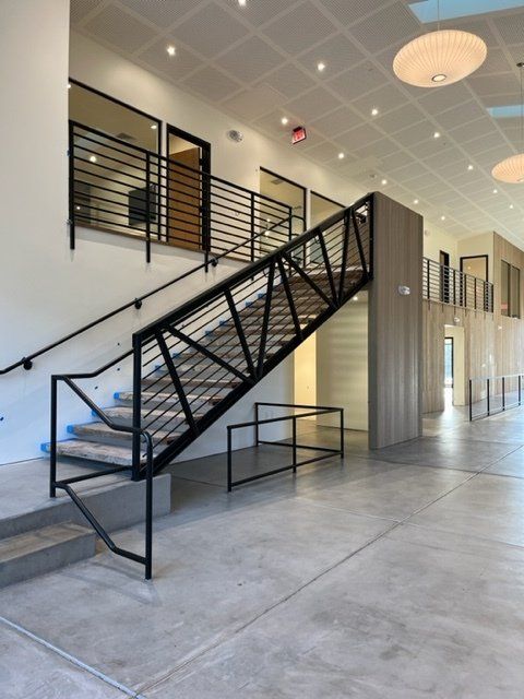 A staircase in a building with a black railing