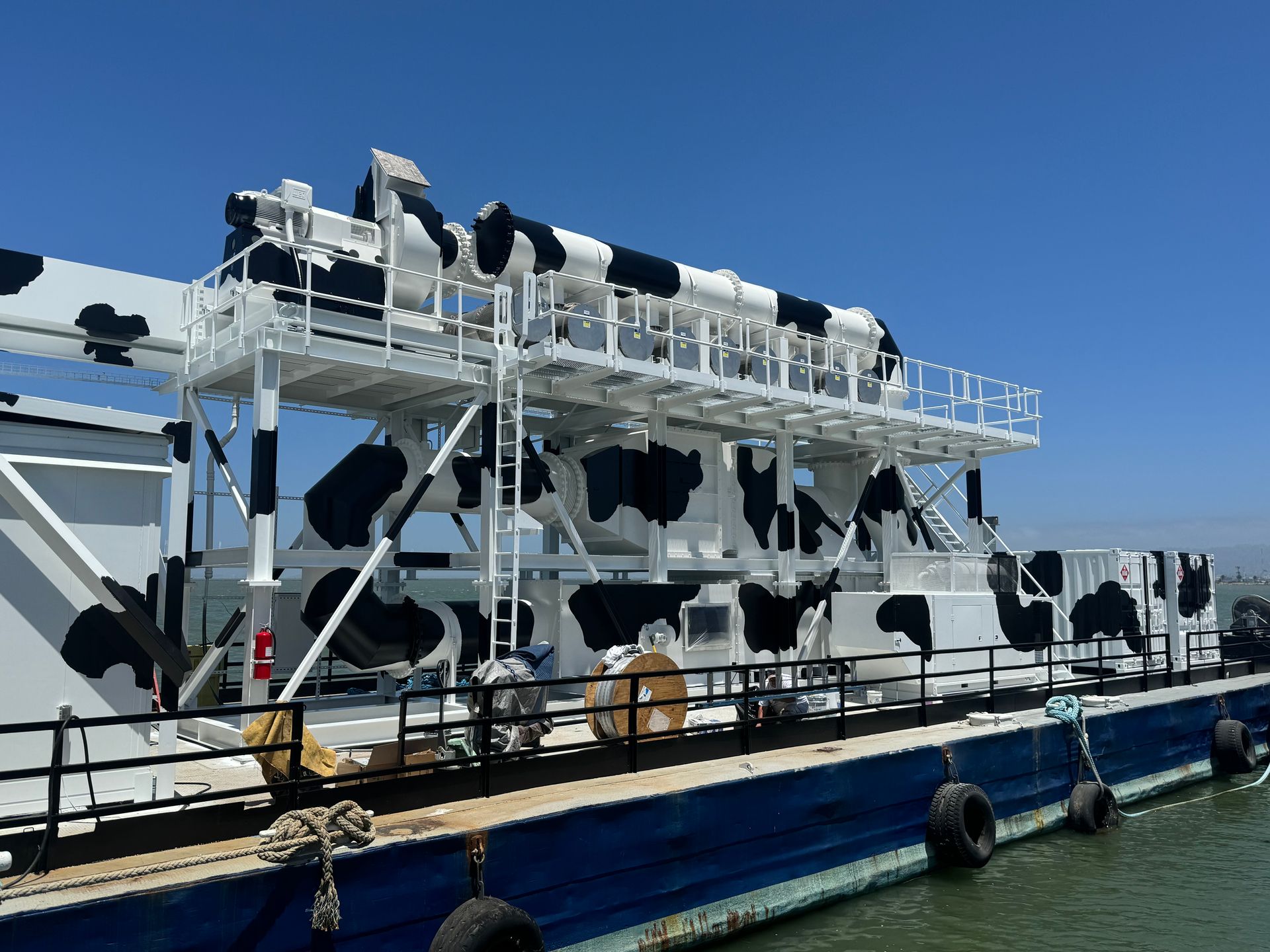 A boat with cows painted on it is docked in the water