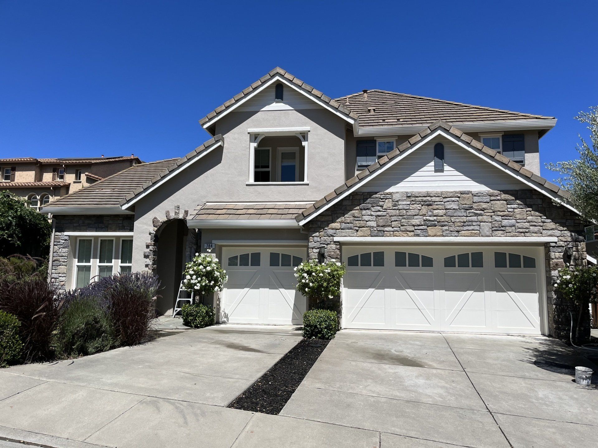 A large house with two garage doors and a driveway