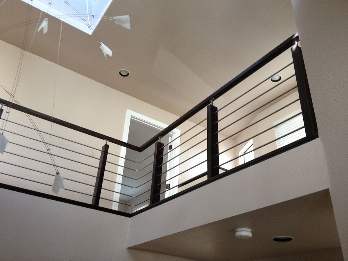 A staircase with a railing and a skylight above it