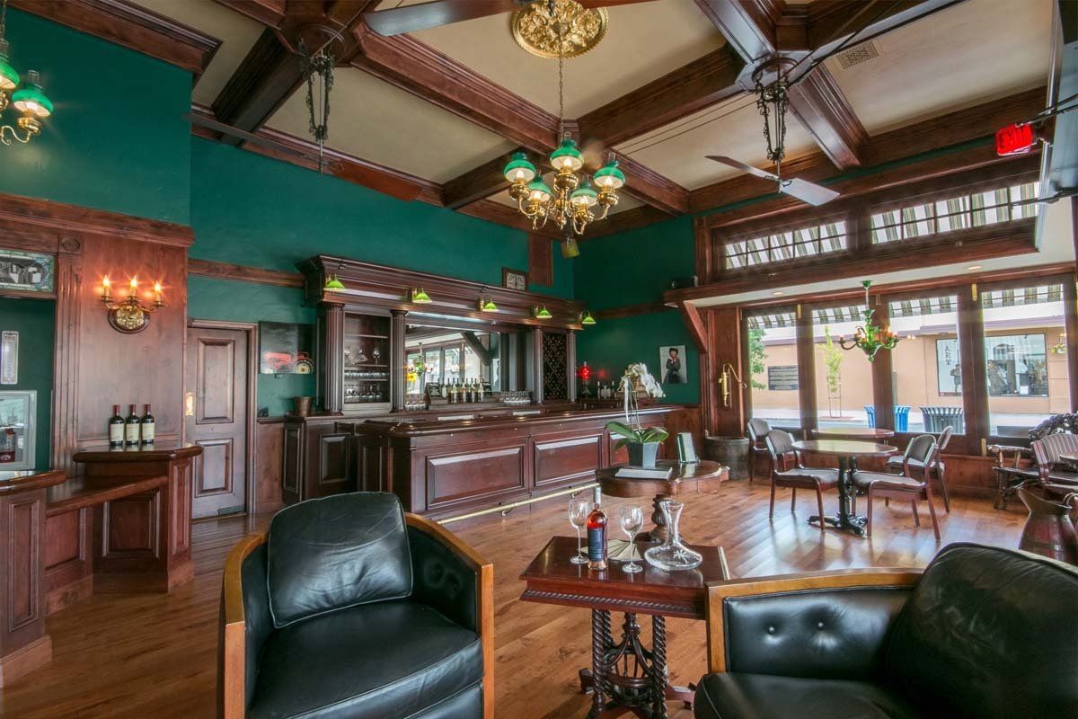A large room with a bar and chairs in it