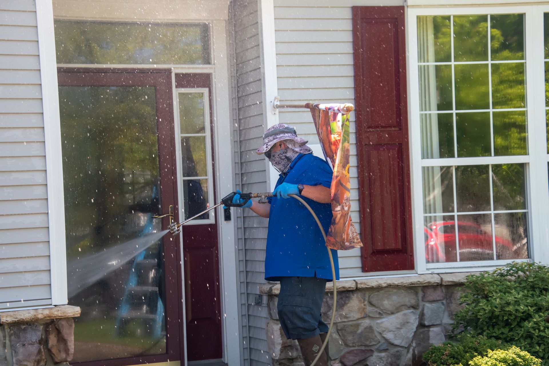 A man is spraying a house with a hose