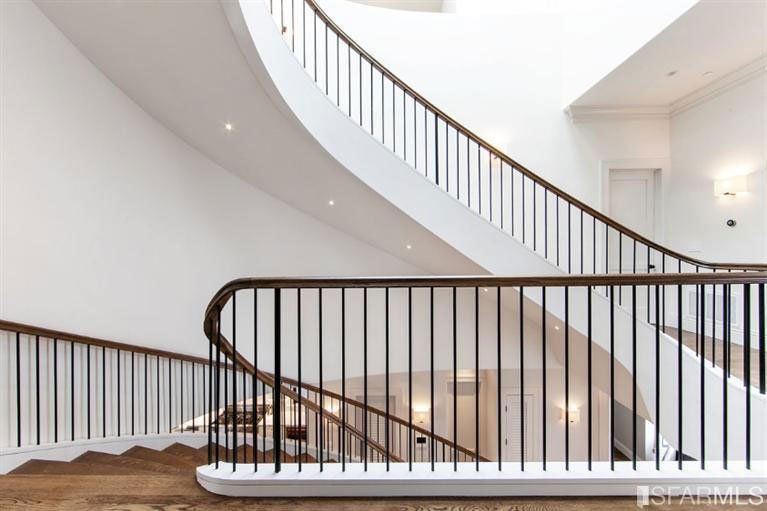 A spiral staircase with a wooden railing in a house