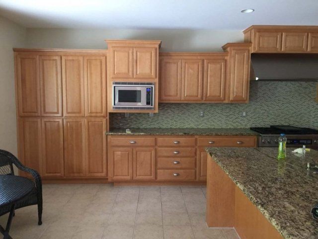 A kitchen with wooden cabinets and granite counter tops