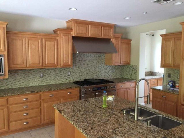 A kitchen with wooden cabinets and granite counter tops