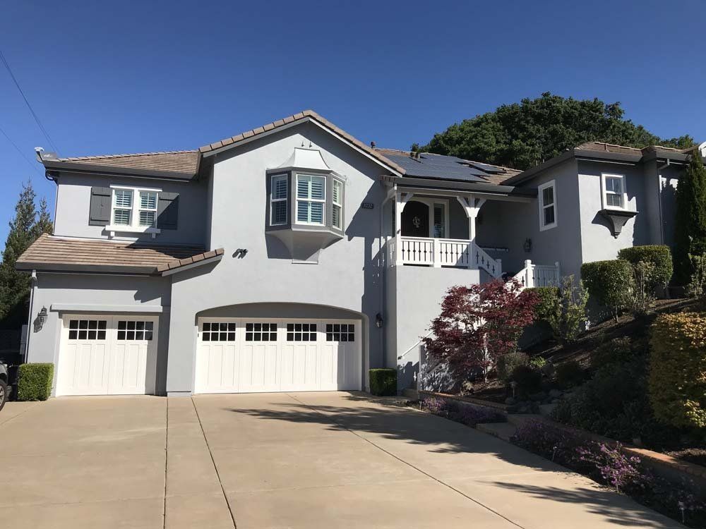 A large house with two garage doors and a large driveway
