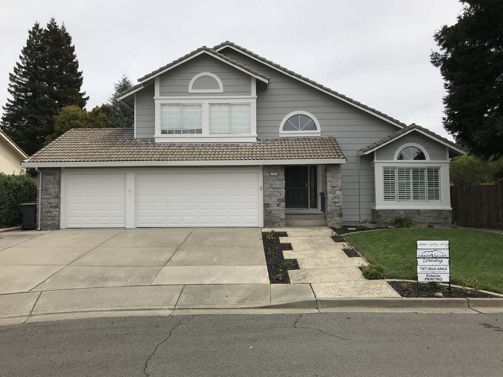 A large grey house with a white garage door