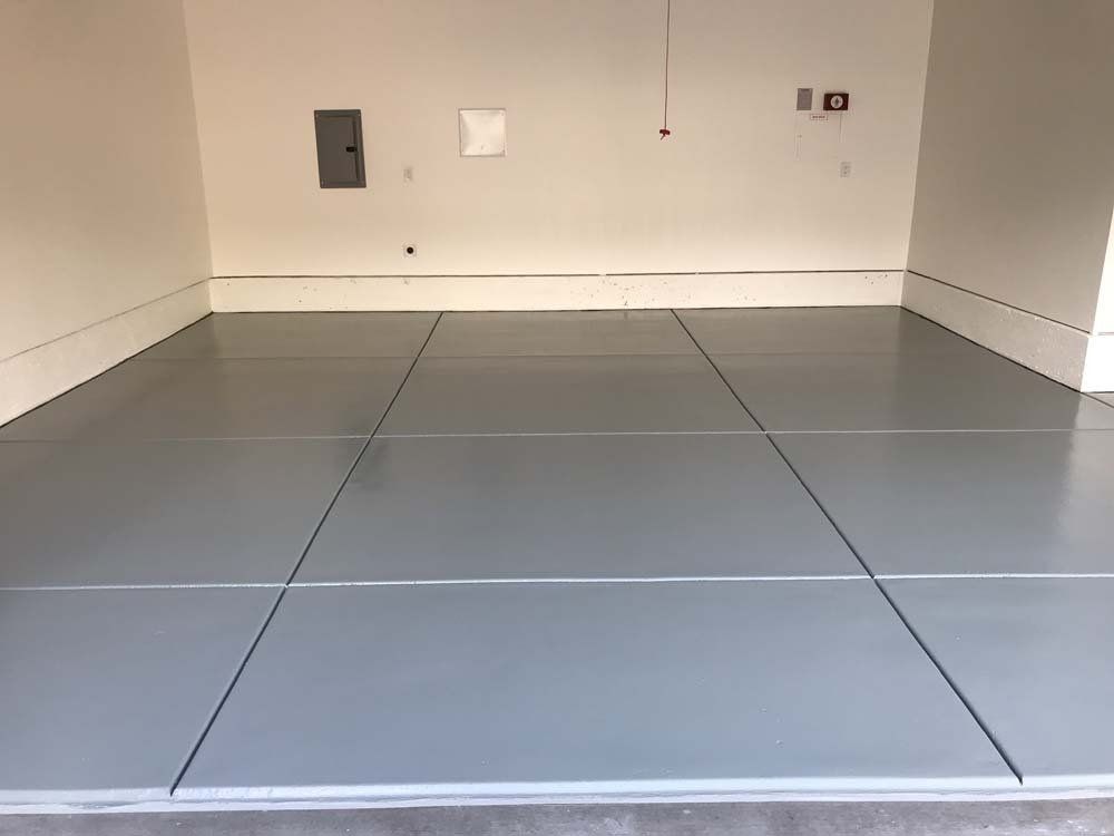 A garage with a gray floor and white walls.