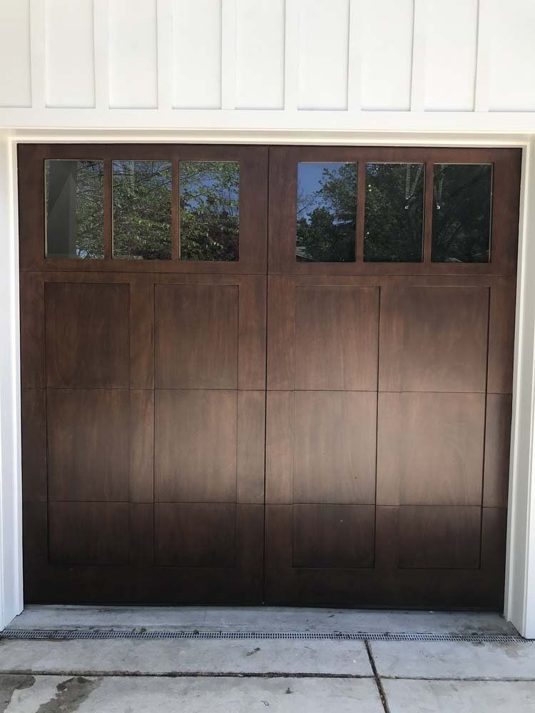 A close up of a wooden garage door with a window.