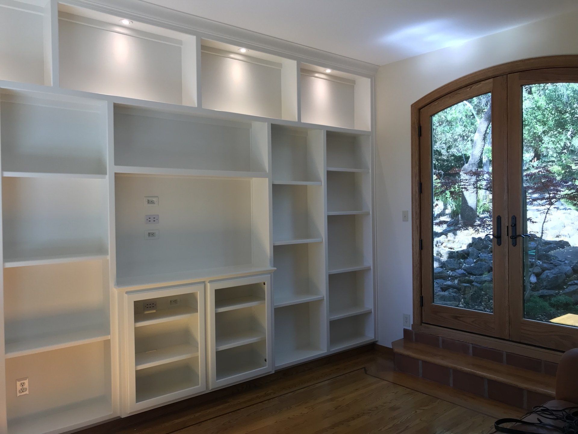 A room with a lot of shelves and a window