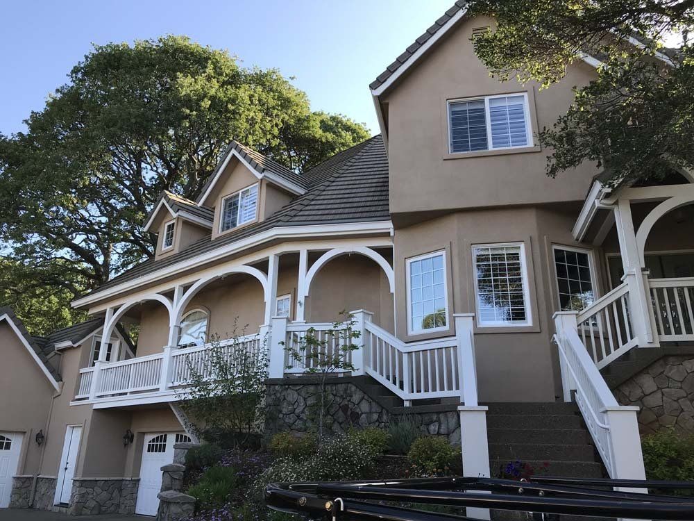 A large house with a white railing and stairs