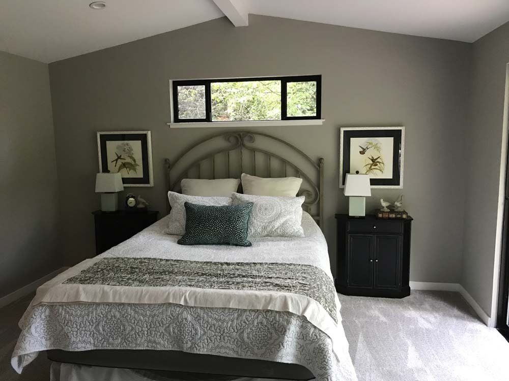 A bedroom with a bed , two nightstands and a window