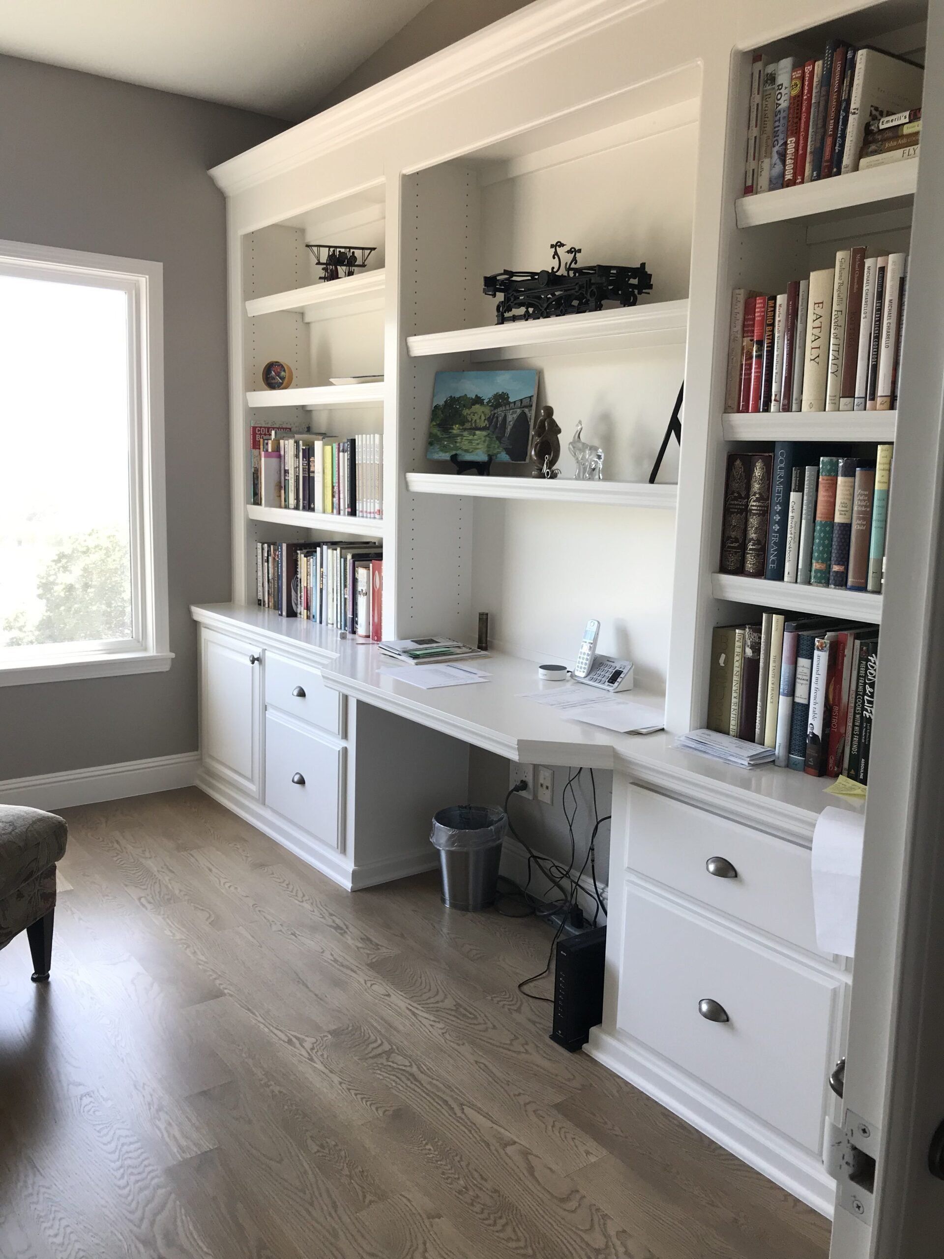 A room with a desk and shelves filled with books