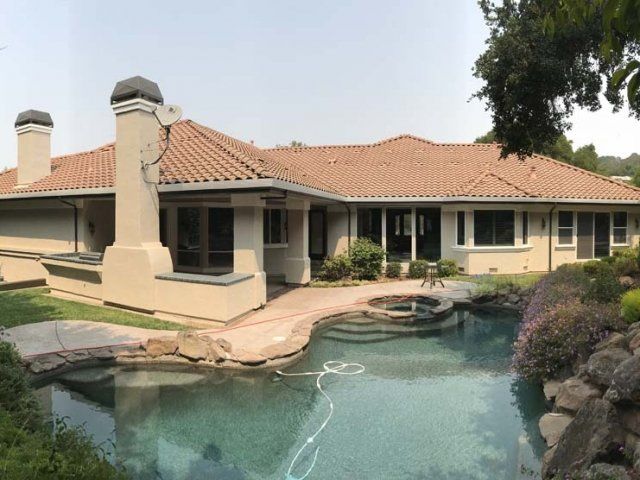 A large house with a swimming pool in front of it