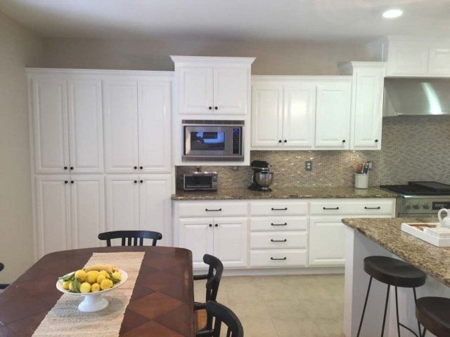 A kitchen with white cabinets and granite counter tops