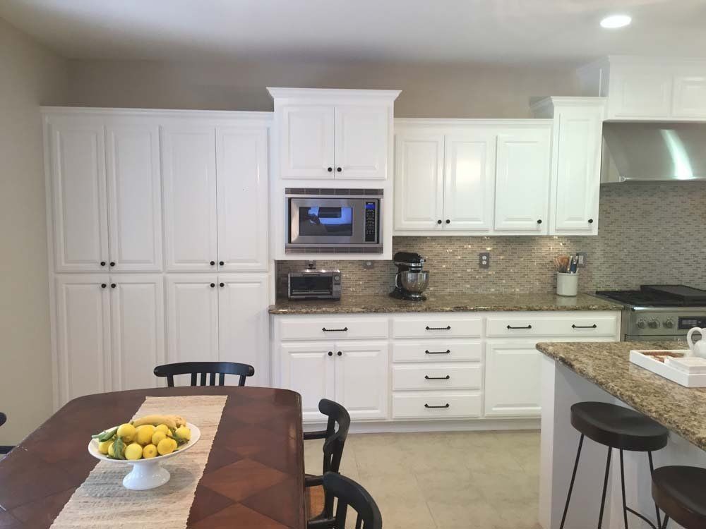 A kitchen with white cabinets and granite counter tops