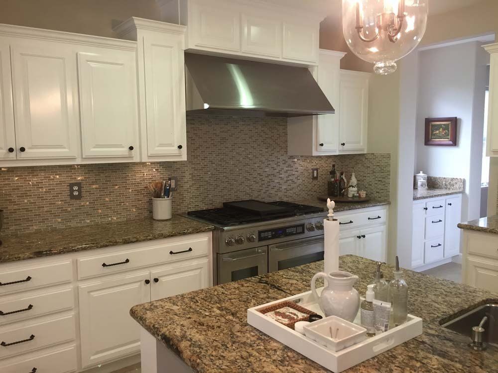 A kitchen with white cabinets and granite counter tops