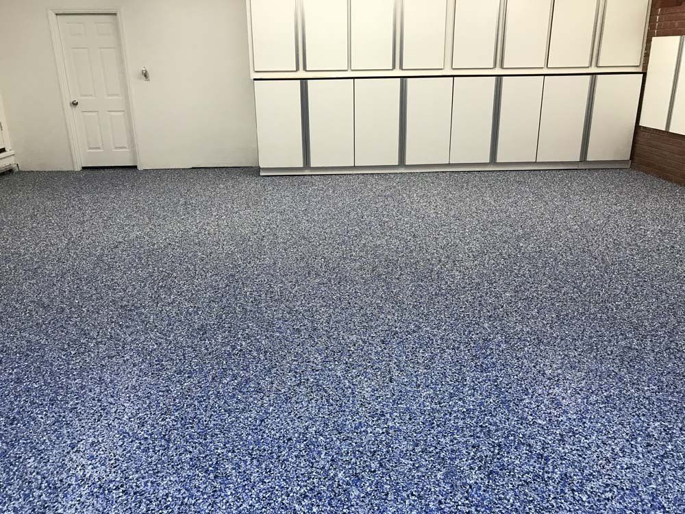 A large room with a blue floor and white cabinets.