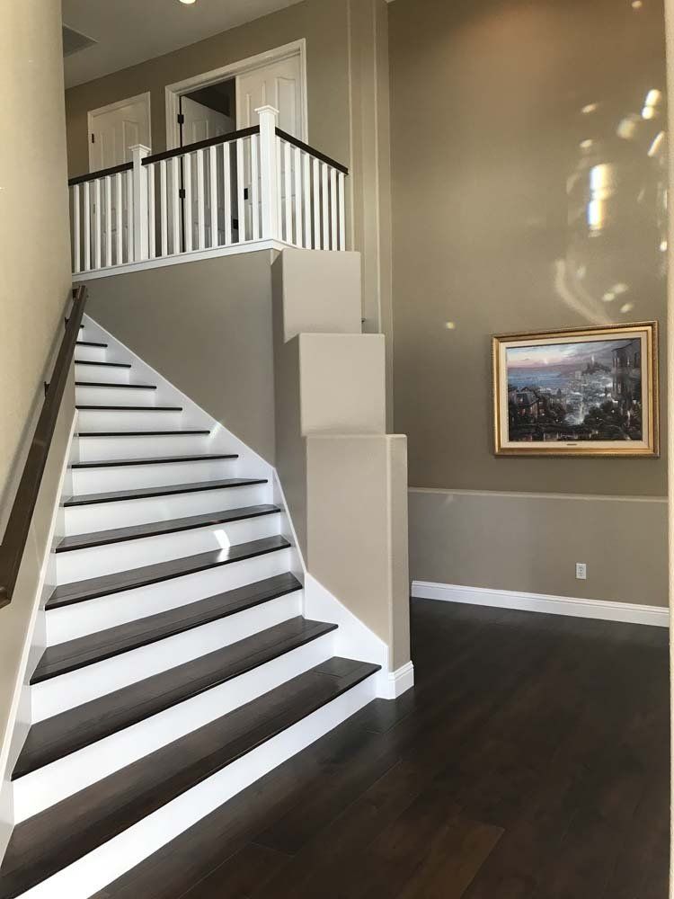 A staircase in a house with a picture on the wall above it