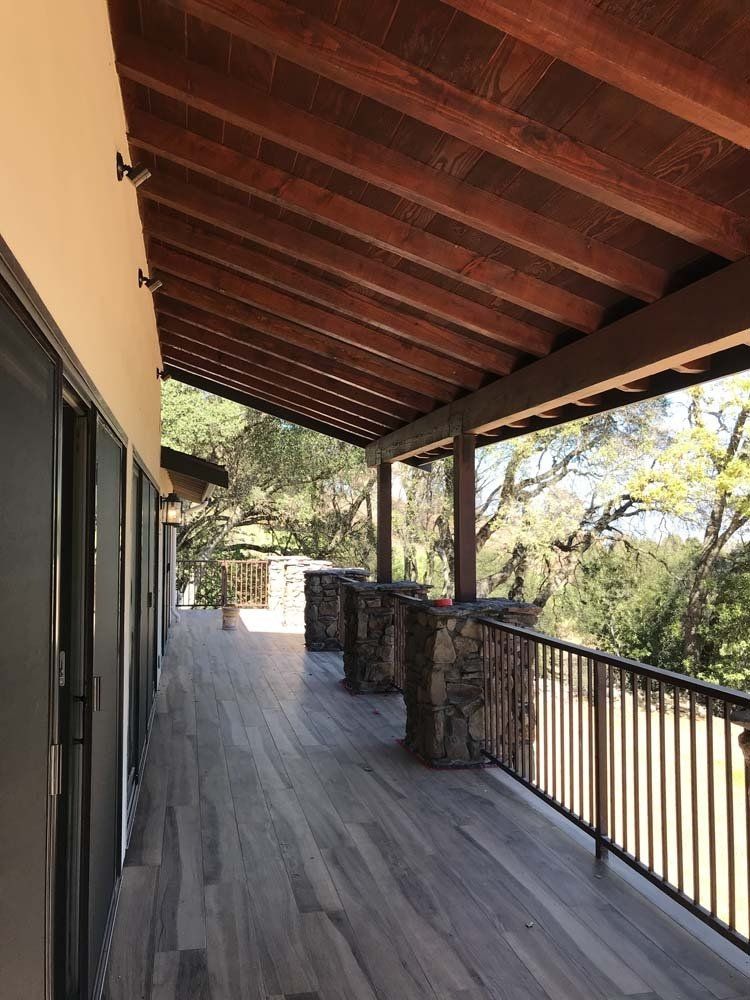 A large balcony with a wooden roof and a metal railing.