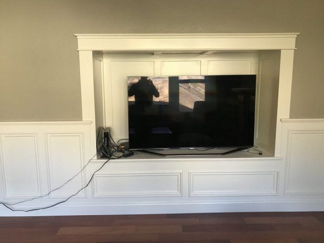 A flat screen tv is sitting in a built in entertainment center.