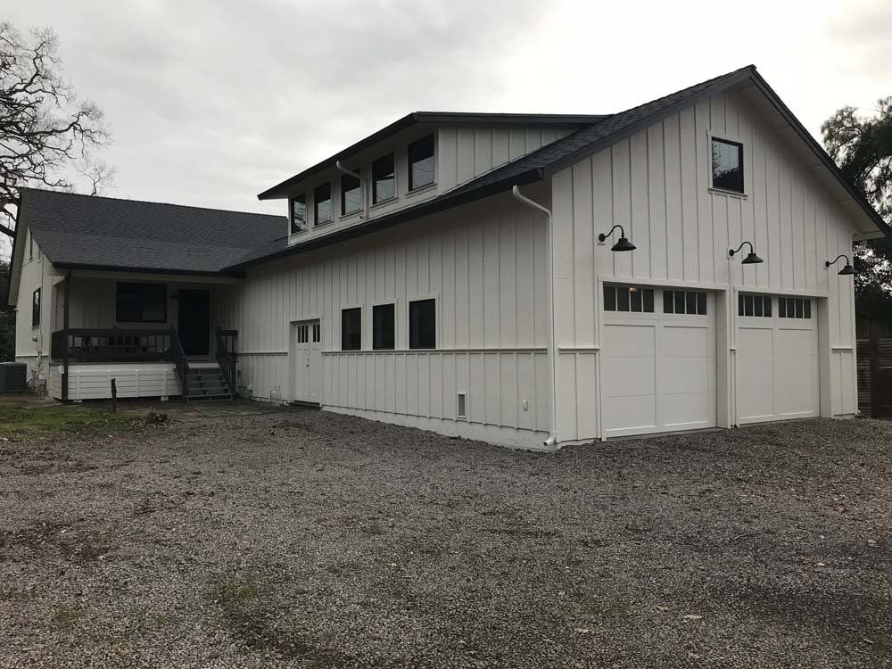 A large white house with a garage and a porch.
