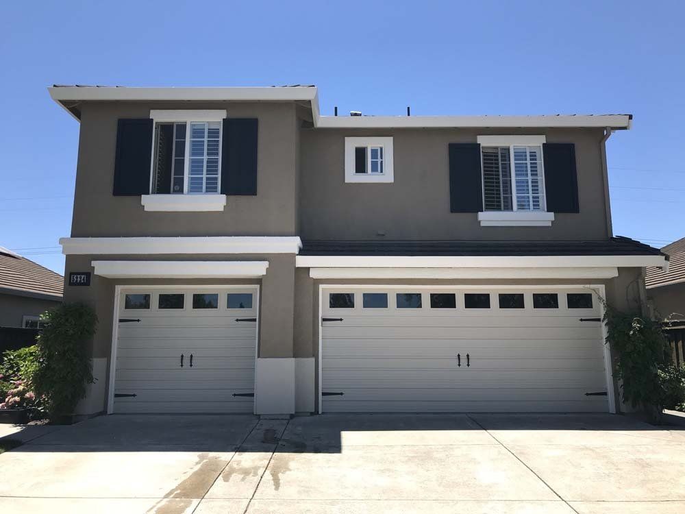 A house with two garage doors and black shutters