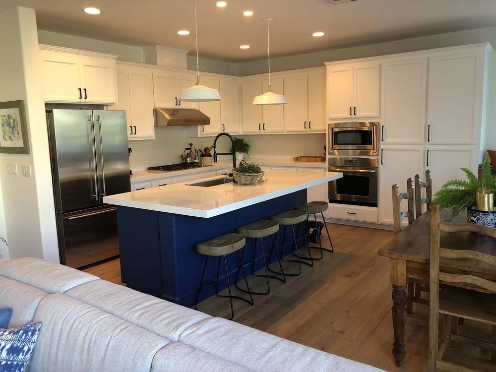 A kitchen with a blue island and white cabinets