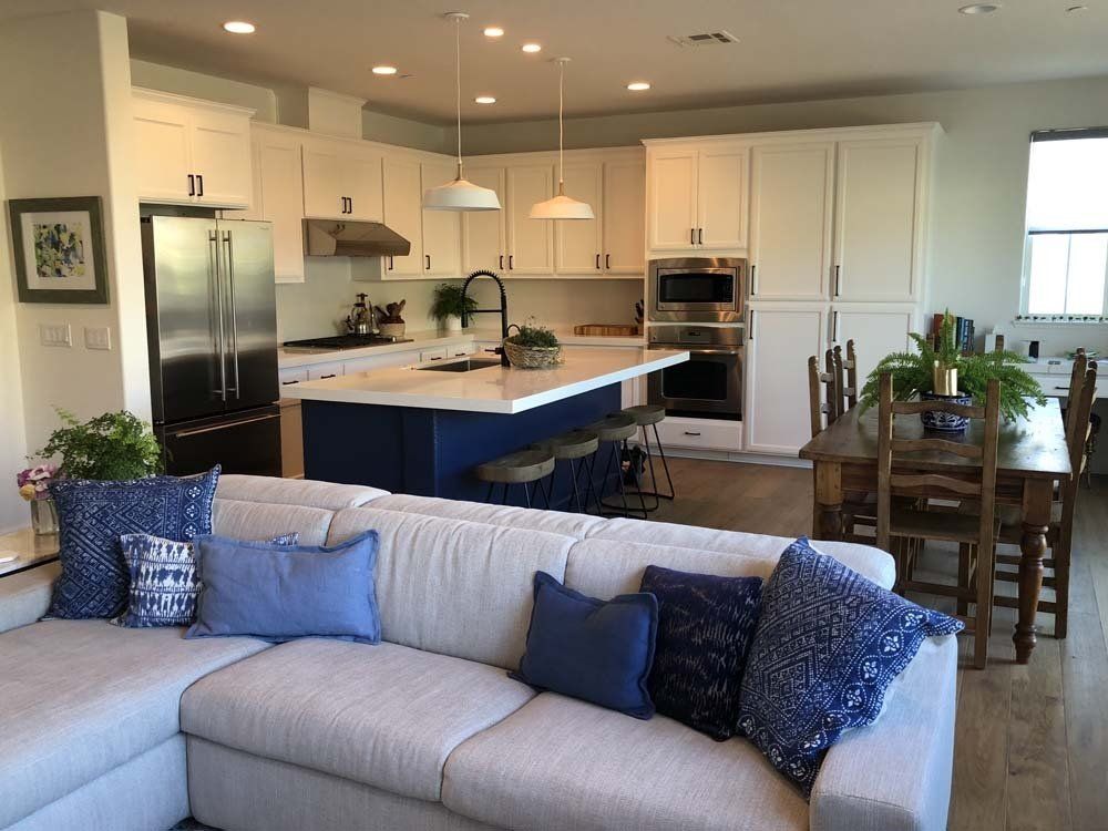 A living room with a couch and a kitchen in the background