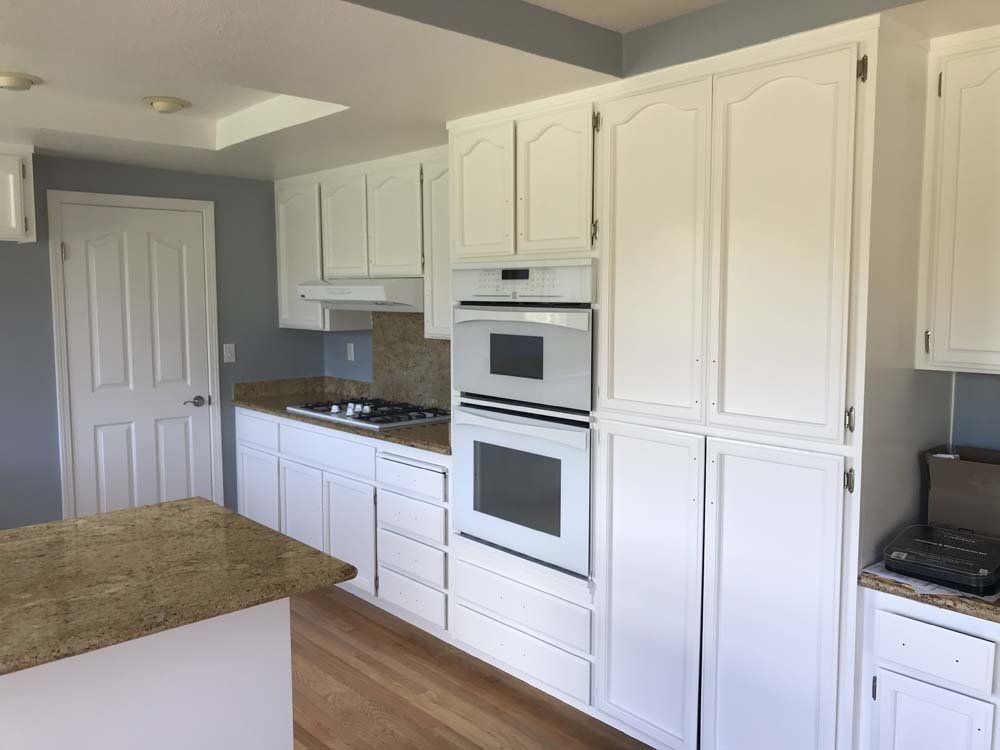 A kitchen with white cabinets and granite counter tops